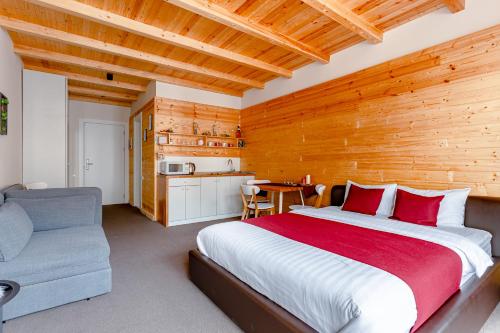 1 dormitorio con 1 cama grande y pared de madera en New Gudauri GoodHost Apartments, en Gudauri