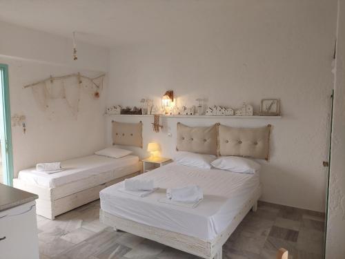 two beds in a room with white walls at Brunis Apartments in Nei Poroi