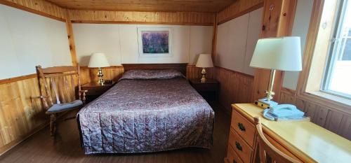 niewielka sypialnia z łóżkiem i 2 lampami w obiekcie Auberge Motel 4 Saisons w Blanc-Sablon