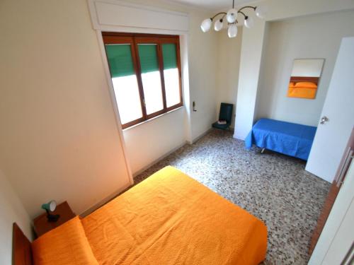 a bedroom with an orange bed and a window at Apartment for rent with parking spaces in Torre dellOrso Pt06 in Torre dell'Orso