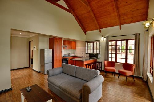 a living room with a couch and a kitchen at Dunkeld Country & Equestrian Estate in Dullstroom