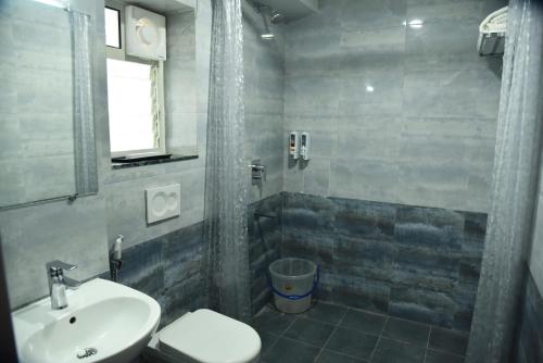 een badkamer met een wastafel, een douche en een toilet bij The Altruist Business Stays- New Town, Kolkata in Calcutta