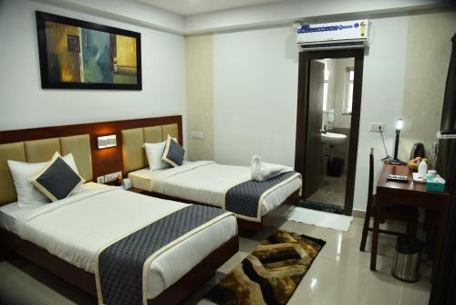 Habitación de hotel con 2 camas y escritorio en The Altruist Business Stays- New Town, Kolkata en Calcuta
