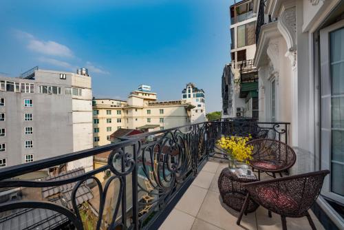 a balcony with chairs and a view of buildings at Sunline Hotel in Hanoi