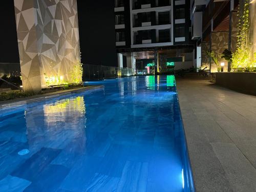 a swimming pool at night in a building at The Emerald Golf View in Thuan An