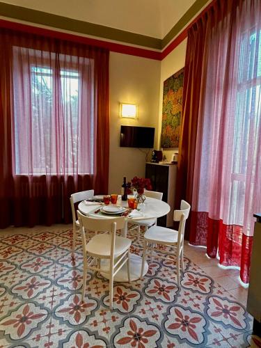 a dining room with a table and chairs and curtains at Villa Pandolfi in Pescara