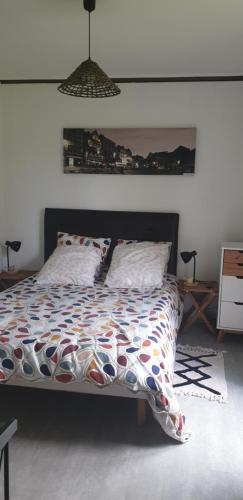 um quarto com uma cama com um edredão colorido em LES HIRONDELLES em Ingouville