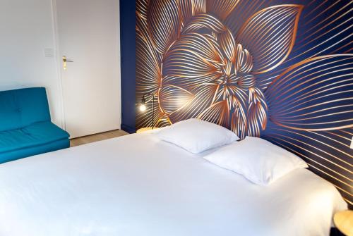 a bedroom with a white bed with a flower mural on the wall at 8 min de la plage, 2 de la gare, 15 de St-Nazaire in La Baule
