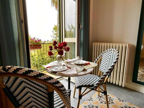 una mesa con un jarrón de flores y dos sillas en Villa Pandolfi en Pescara