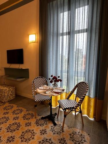 a room with a table and two chairs and a window at Villa Pandolfi in Pescara