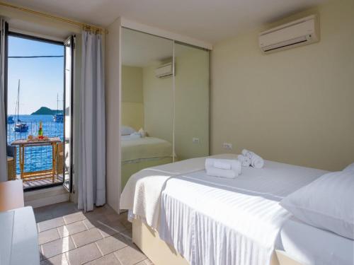 a bedroom with a bed and a view of the ocean at Villa Lola in Lopud