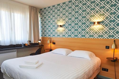 a hotel room with a bed with two towels on it at Auberge du port in Bazeilles