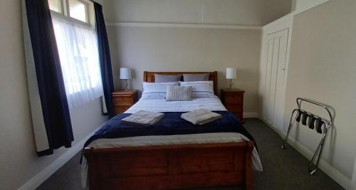 a bedroom with a bed with blue sheets and a window at Character 2-Bedroom Unit in Masterton
