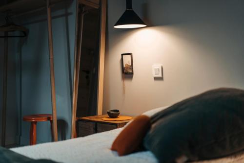 a bedroom with a bed with a table and a lamp at le chalet de Plainpalais in Les Déserts