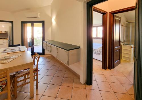 uma cozinha e sala de jantar com uma mesa e uma mesa e cadeiras em Residenza Aldo Moro 02 em La Maddalena