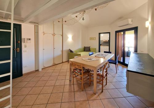 una cucina e un soggiorno con tavolo e divano di Residenza Aldo Moro 02 a La Maddalena