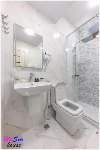 a white bathroom with a sink and a toilet at Masur House and Tours in Yerevan