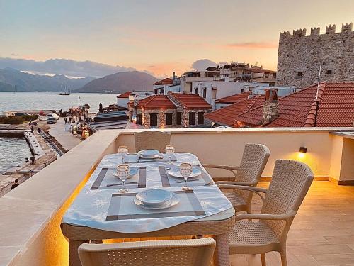 a table on a balcony with a view of the water at Port Mansion in Marmaris