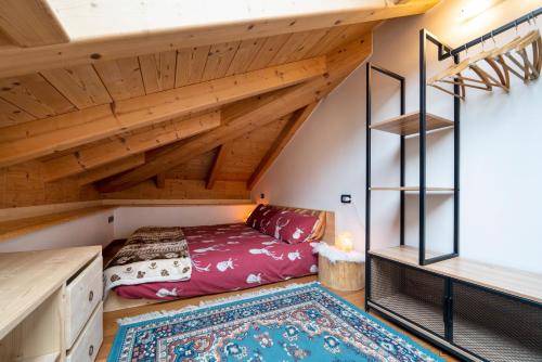 una camera da letto con letto in un soppalco con soffitti in legno di Mansarda Cermis a Cavalese