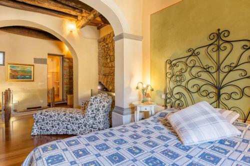 a bedroom with a bed and a chair at Villa Camelia Bianca in Barga