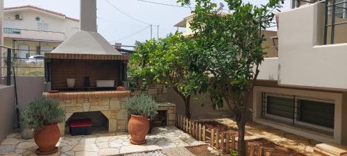 a patio with a brick fireplace and a grill at Aqua in Artemida