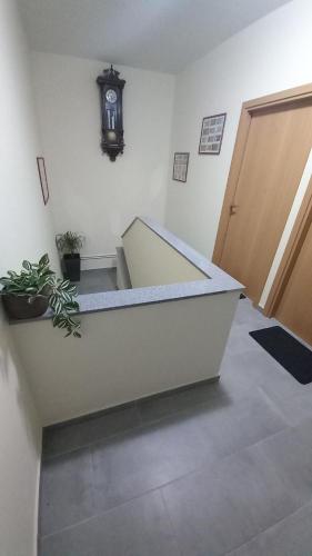 an empty room with a staircase and a clock on the wall at Apartmani i Sobe Kočiš in Bjelovar