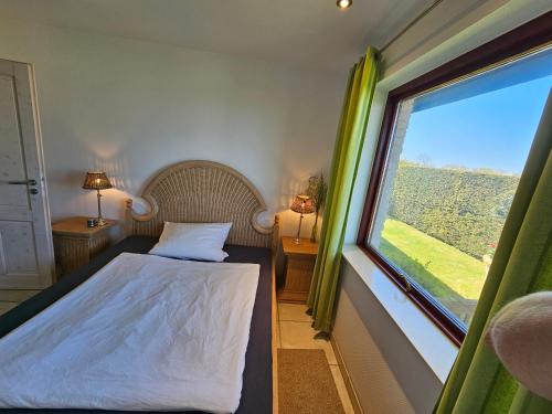 - une chambre avec un lit et une grande fenêtre dans l'établissement Ferienhaus Ostseeblick Schönhagen, à Brodersby