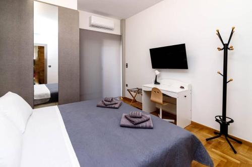 Dormitorio con cama, escritorio y TV en LK Apartment -A- Metro Larissis 6' Walk - Athens, en Atenas