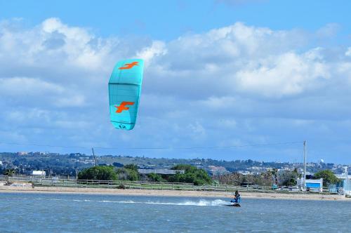 a person is kite surfing in the water at Casa B, Room 6 - mit Pool - at Lagoon - Lo Stagnone Kite Spot - Palm Kite Paradise in Marsala