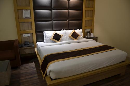 a bedroom with a large bed with a large headboard at Tulip Tree Hotel in Katra