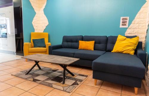 a living room with a blue couch and a table at Maison de Ville restylée avec jardin, proche gare in Dunkerque