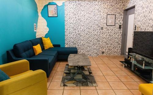 a living room with a blue couch and a tv at Maison de Ville restylée avec jardin, proche gare in Dunkerque