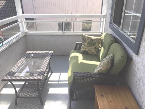 a balcony with a couch and a table and a window at SFU comfortable house in Burnaby