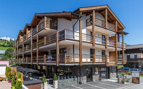 a large building with wooden balconies on it at 24 by AvenidA - Mountain Hotel in Kaprun