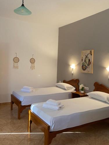 dwa łóżka w pokoju z dwoma stołami w obiekcie Dream Catcher 5 w mieście Agia Theodoti