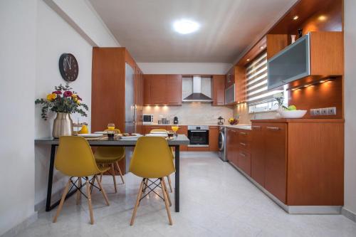 a kitchen with a table and yellow chairs at Christina's House in Afantou