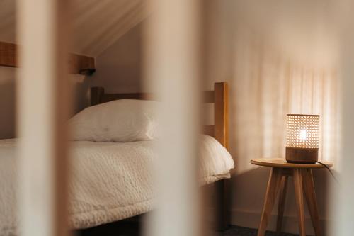 a bedroom with a bed and a table with a lamp at le chalet de Plainpalais in Les Déserts