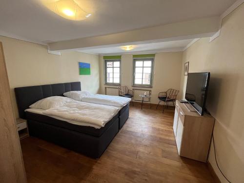 um quarto com uma cama e uma televisão de ecrã plano em Gasthaus Zum Goldenen Hirsch em Schriesheim