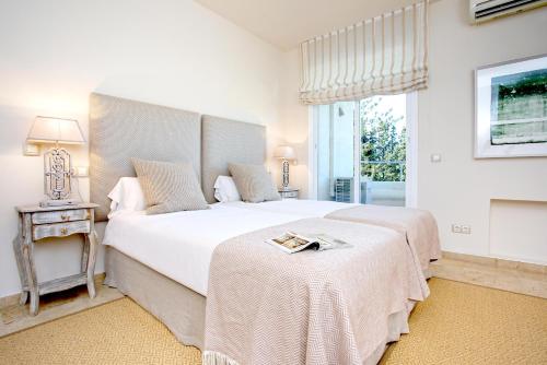 Un dormitorio con una gran cama blanca y una ventana en Genteel Home Flamencos Terrace, en Marbella