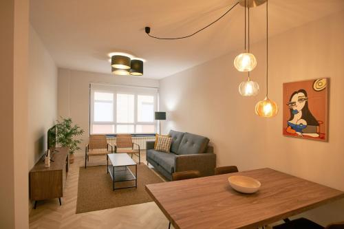 - un salon avec un canapé et une table dans l'établissement Apartamentos Los Arroyos, à Ponferrada