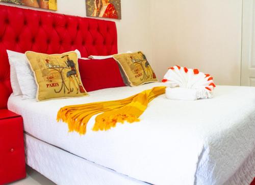 two beds in a room with a red headboard at Eagles Nest Self-Catering Apartments in Gaborone