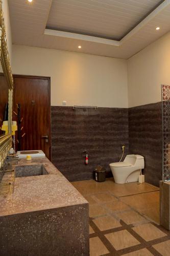a bathroom with a toilet and a sink at Casa de Saka Villa in Ngaglik