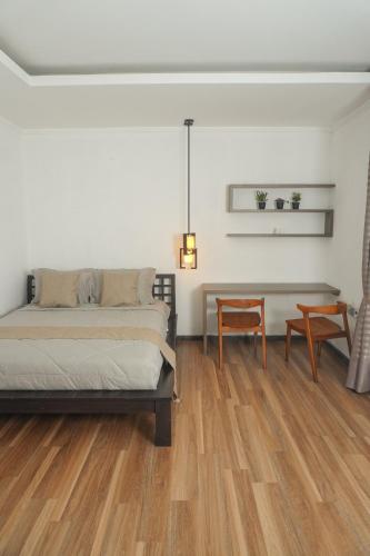 a bedroom with a bed and a table and chairs at Casa de Saka Villa in Ngaglik