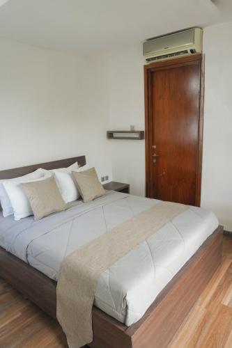 a bedroom with a large bed with a wooden door at Casa de Saka Villa in Ngaglik