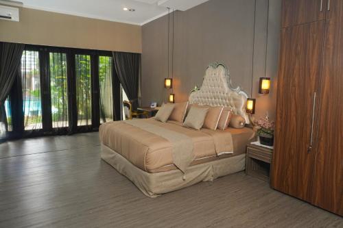 um quarto com uma cama grande e uma grande cabeceira. em Casa de Saka Villa em Ngaglik