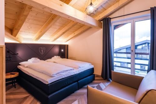 a bedroom with a large bed and a large window at 24 by AvenidA - Mountain Hotel in Kaprun