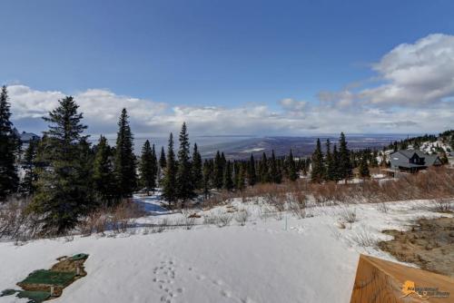 a snow covered hill with footprints in the snow at The Mountain Top Escape w/Scenic Views & Trails in Anchorage