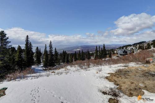 a snow covered hill with footprints in the snow at The Mountain Top Escape w/Scenic Views & Trails in Anchorage