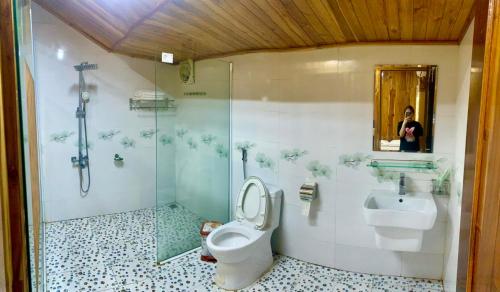 a bathroom with a shower and a toilet and a sink at Hang Lan Bungalow in Ninh Binh
