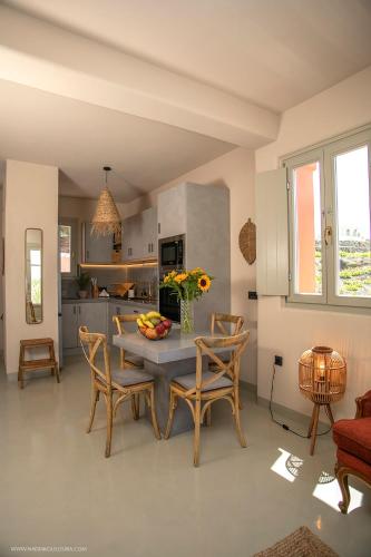 a kitchen and dining room with a table and chairs at Pink Freud Villas Santorini in Oia
